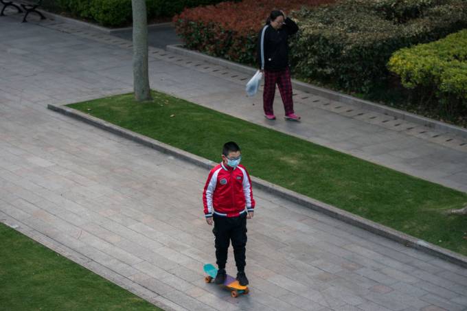 foto de uma criança chinesa com máscara andando de skate